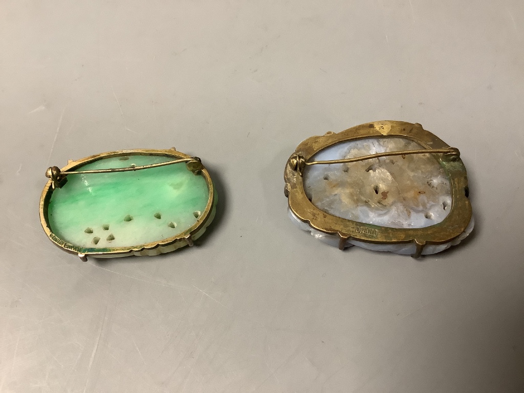 A Chinese jadeite plaque mounted as a brooch, 47mm and a Chinese blue chalcedony ‘lion-dog’ brooch, 46mm, both early 20th century